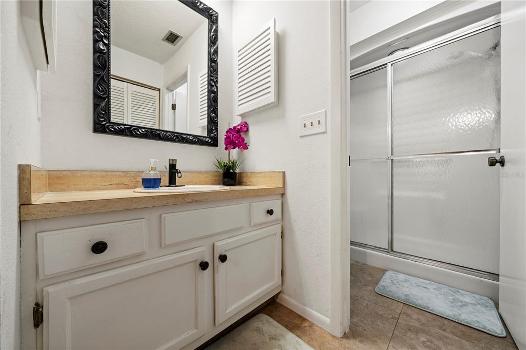 7360 Ulmerton Road, Unit 15D Largo, FL 33771 - Photo 26 of 75 a bathroom with a shower sink and mirror
