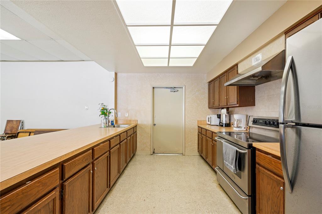 7360 Ulmerton Road, Unit 15D Largo, FL 33771 - Photo 50 of 75 a kitchen with stainless steel appliances granite countertop a sink a stove and a refrigerator
