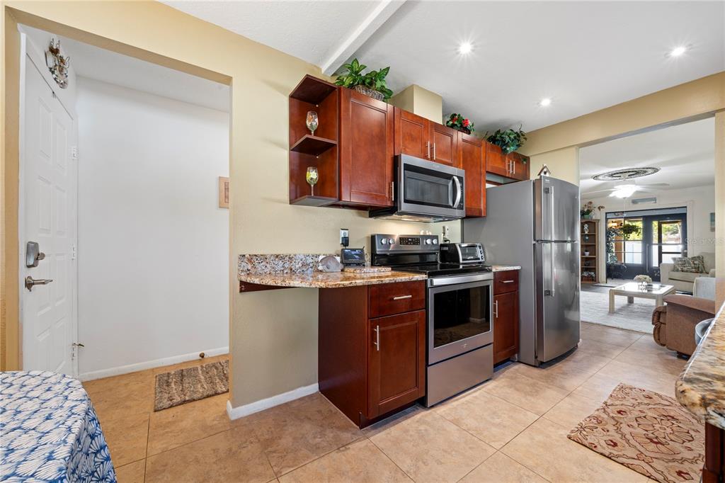 7360 Ulmerton Road, Unit 15D Largo, FL 33771 - Photo 10 of 75 a kitchen with stainless steel appliances granite countertop a stove a sink and a refrigerator