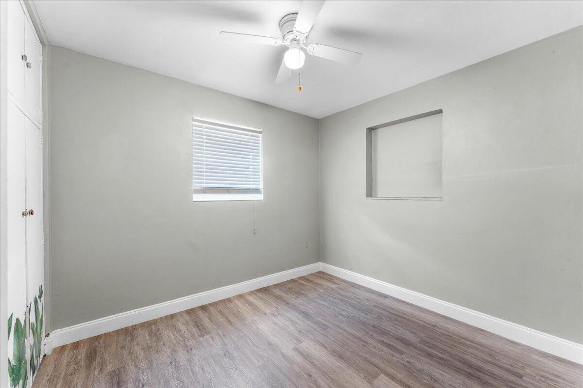 3308 Purdue Street Melbourne, FL 32901 - Photo 20 of 43 an empty room with wooden floor ceiling fan and windows