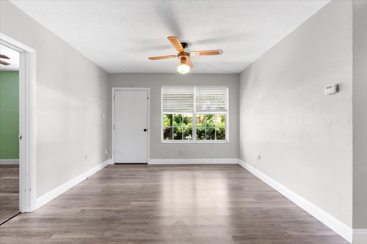 3308 Purdue Street Melbourne, FL 32901 - Photo 4 of 43 an empty room with wooden floor chandelier fan and windows
