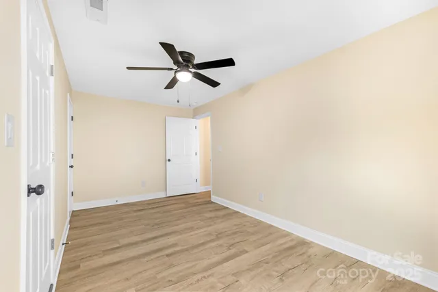 a view of a big room with wooden floor and a ceiling fan