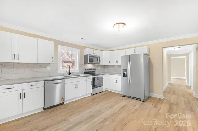 a kitchen with a refrigerator and white cabinets