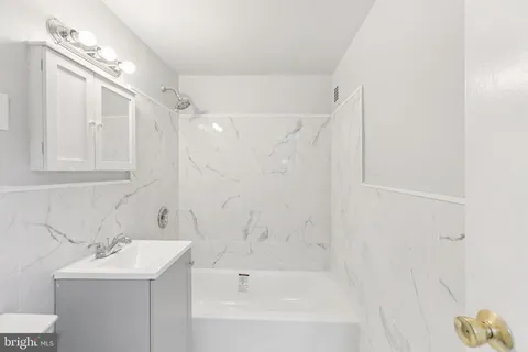 a bathroom with a bathtub a sink a toilet and a shower