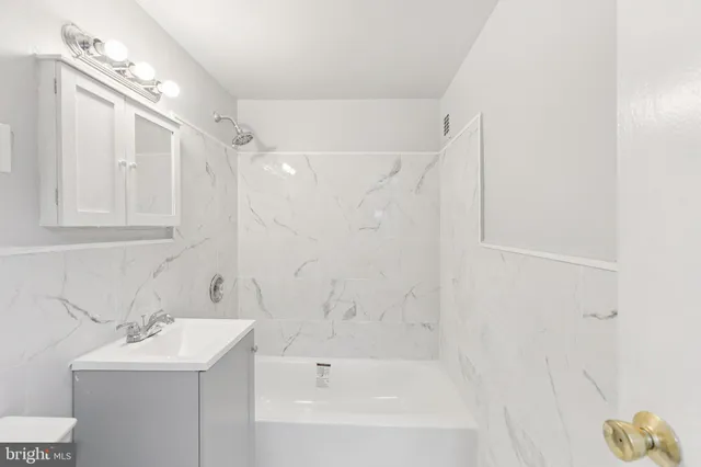 a bathroom with a bathtub a sink a toilet and a shower