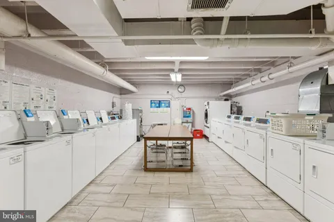 a kitchen with stainless steel appliances kitchen island granite countertop a sink and white cabinets