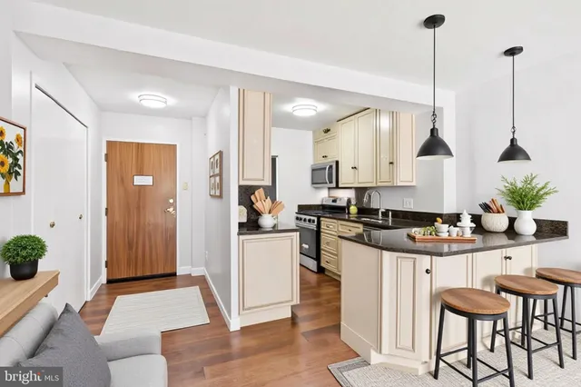 a kitchen with stainless steel appliances kitchen island granite countertop a stove a sink and a refrigerator