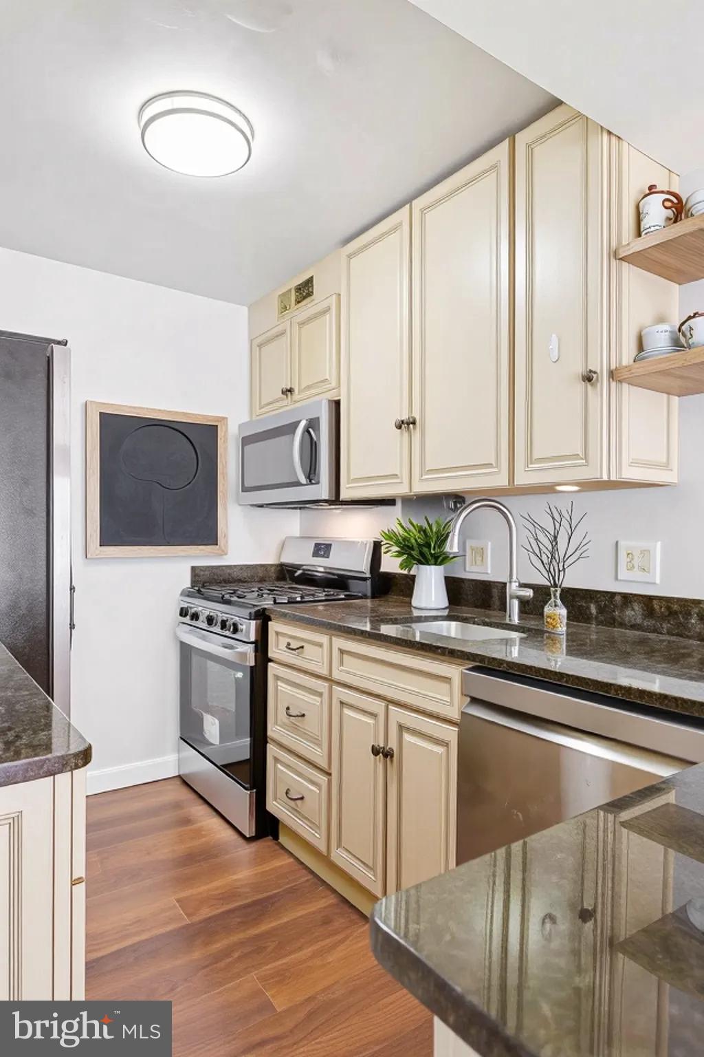 730 24th Street Northwest, Unit 321 Washington, DC 20037 - Photo 6 of 20 a kitchen with stainless steel appliances granite countertop a stove a sink and a microwave