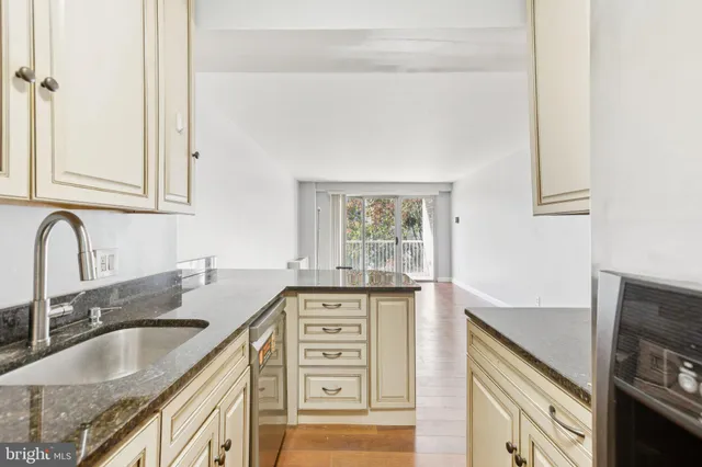 a kitchen with granite countertop a sink a stove and cabinets