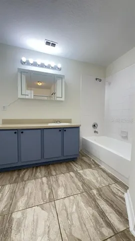 a bathroom with a tub sink and mirror