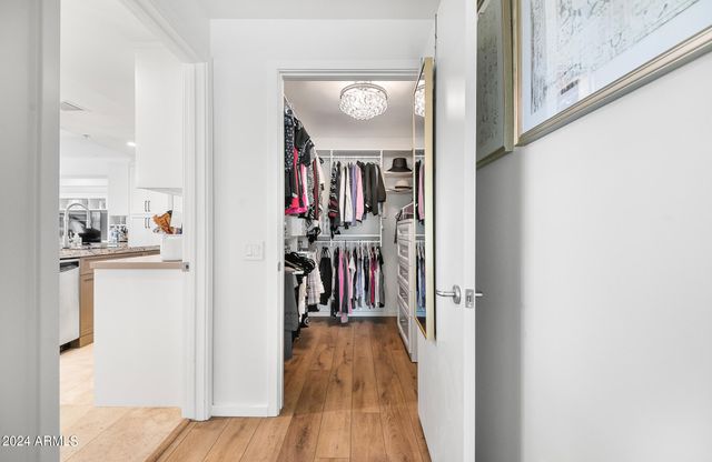 a bedroom with a large bed and a flat tv screen on dresser