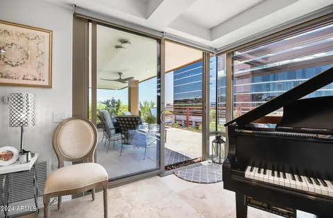 a living room with furniture a piano and a window