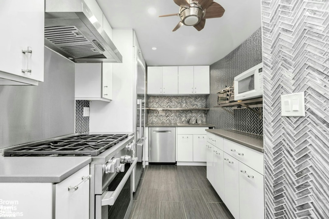 305 East 40th Street, Unit 4F Manhattan, NY 10016 - Photo 2 of 9 a kitchen with stainless steel appliances a sink stove and cabinets