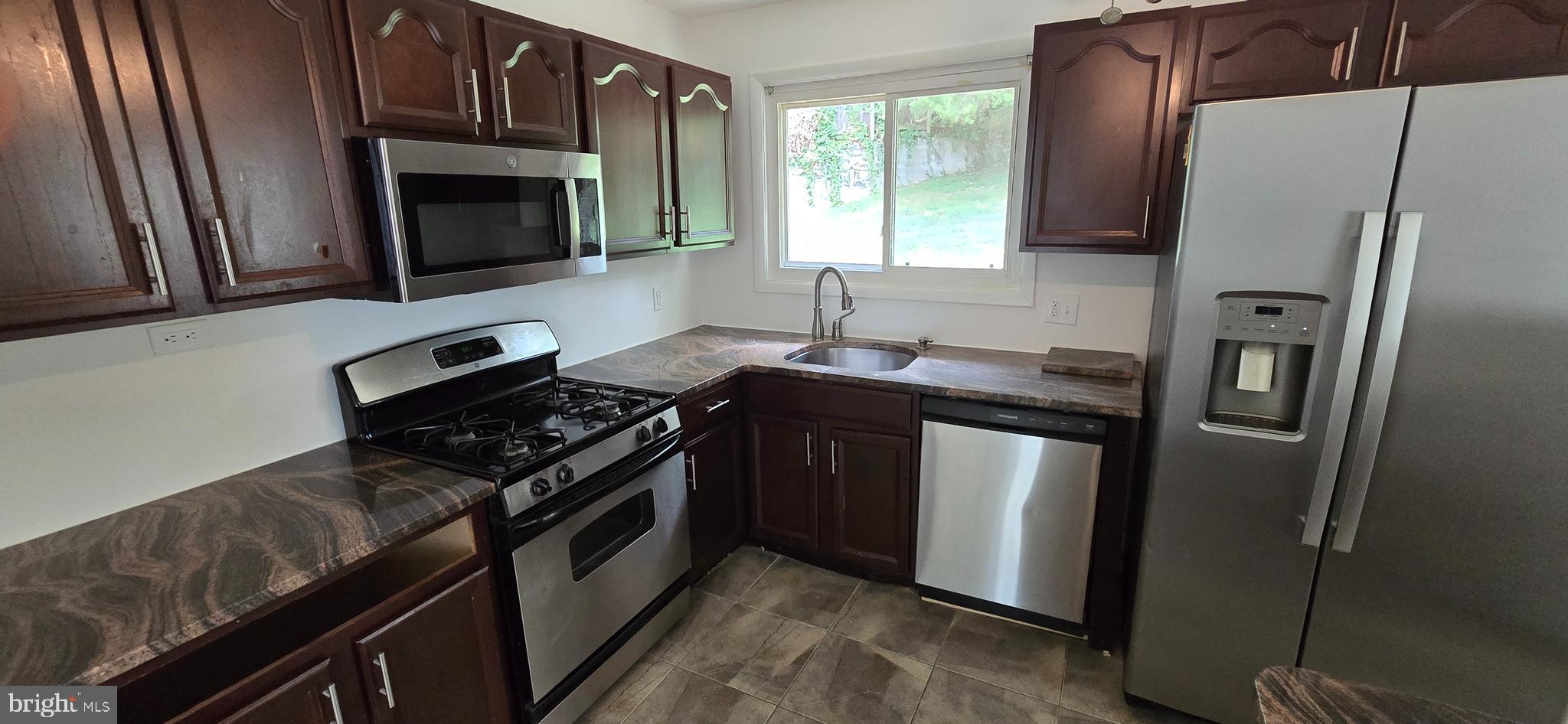 1700 Jarvis Avenue Oxon Hill, MD 20745 - Photo 5 of 15 a kitchen with stainless steel appliances granite countertop a stove microwave refrigerator and sink