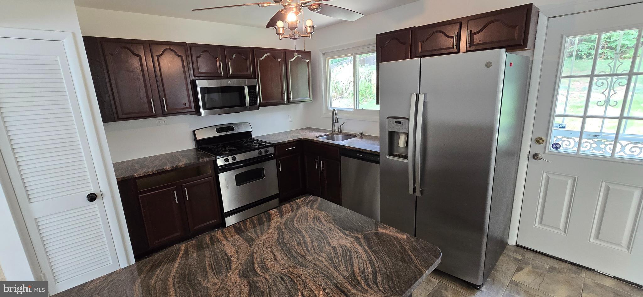 1700 Jarvis Avenue Oxon Hill, MD 20745 - Photo 7 of 15 a kitchen with granite countertop stainless steel appliances a refrigerator a stove a microwave cabinets and a window