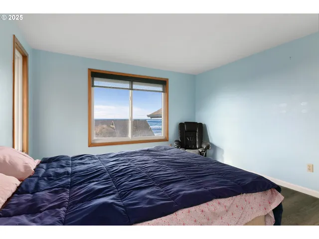 a large bed sitting in a bedroom next to a window