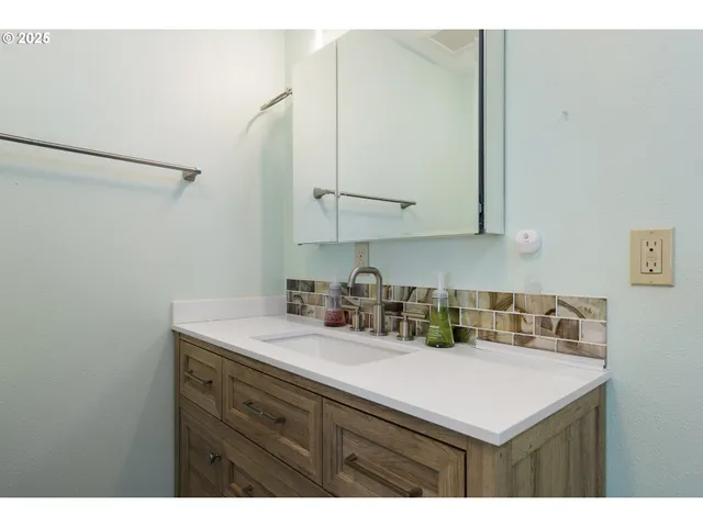a bathroom with a sink vanity and a mirror