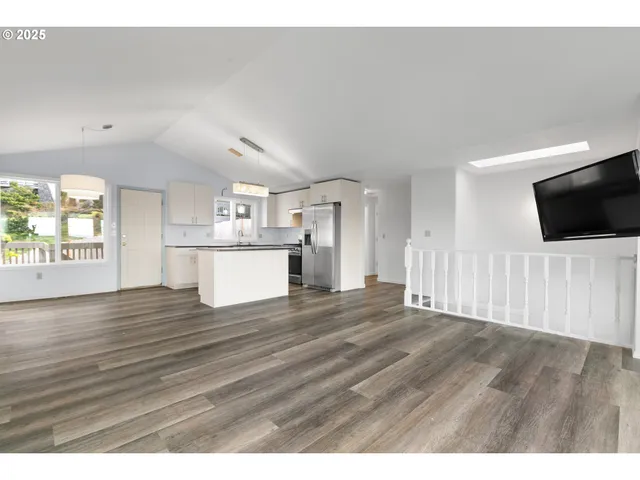 a view of a kitchen with wooden floor and a kitchen space
