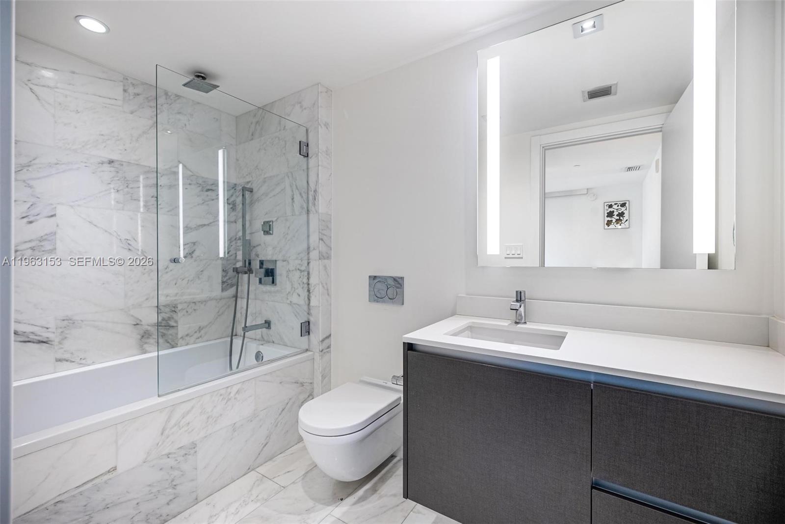 1451 Brickell Avenue, Unit 2204 Miami, FL 33131 - Photo 15 of 29 a bathroom with a sink toilet vanity and shower