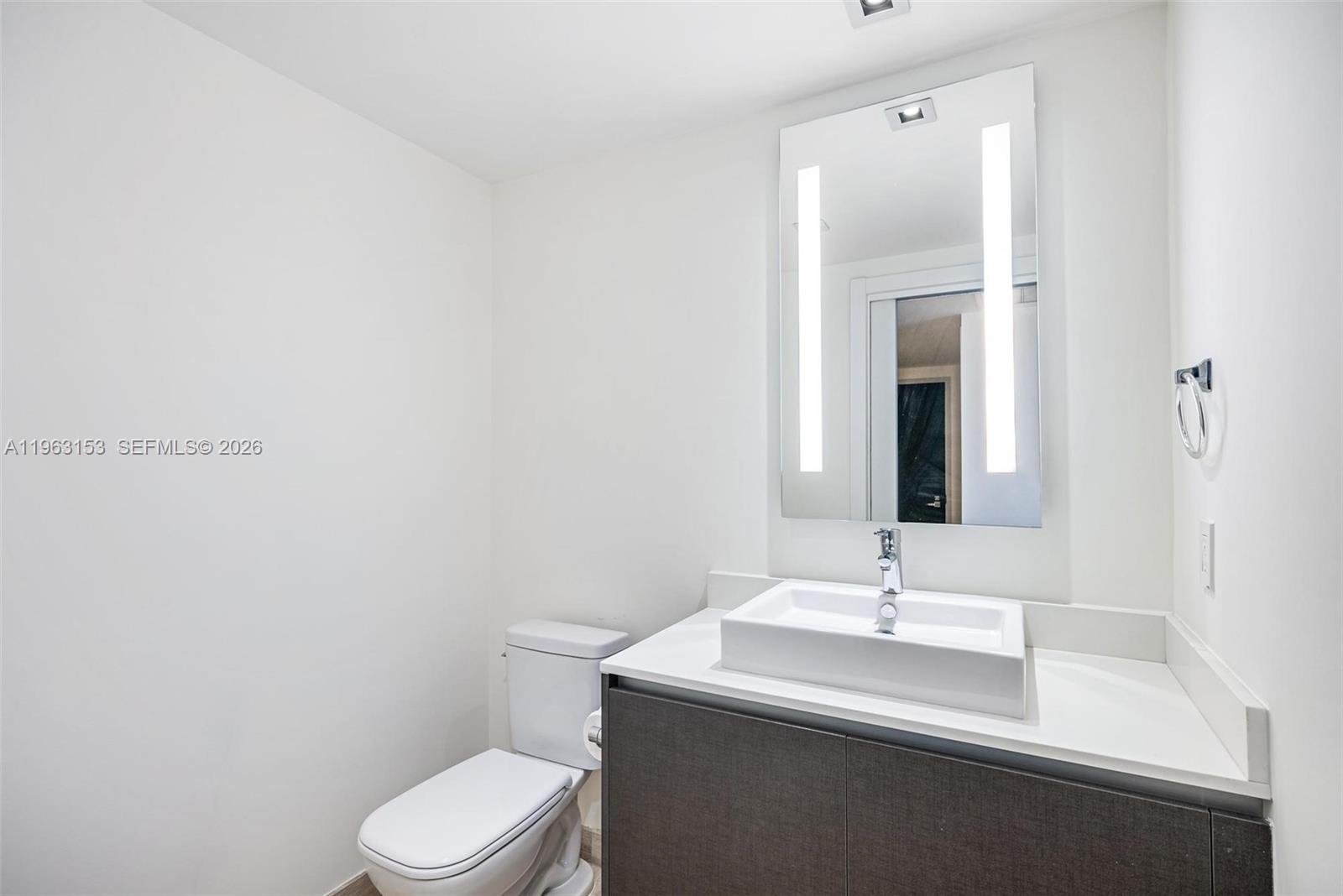 1451 Brickell Avenue, Unit 2204 Miami, FL 33131 - Photo 16 of 29 a bathroom with a sink a toilet and mirror