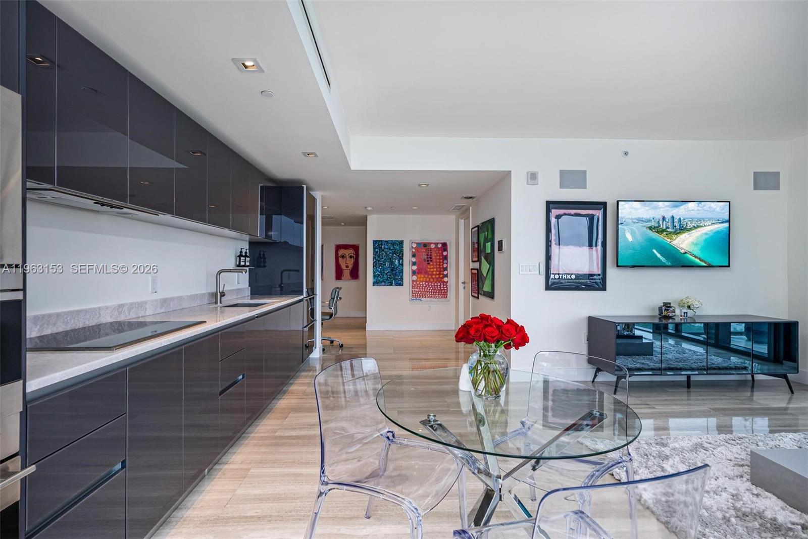 1451 Brickell Avenue, Unit 2204 Miami, FL 33131 - Photo 3 of 29 a dining room with stainless steel appliances kitchen island granite countertop a table and chairs in it