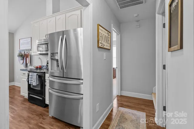 a metallic refrigerator freezer sitting in a kitchen