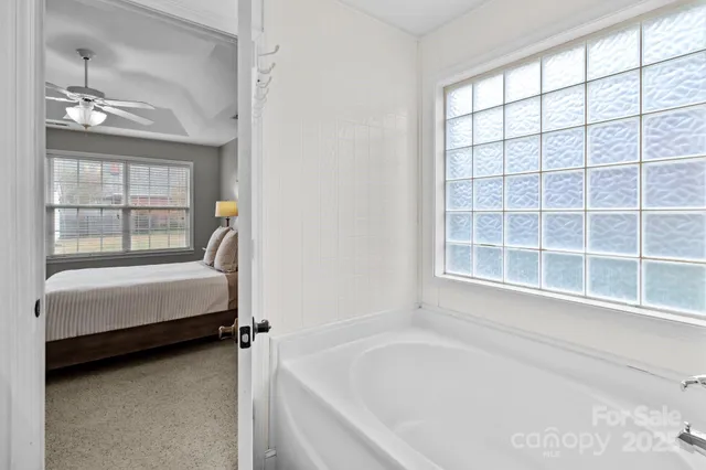 a bathroom with a tub sink and window