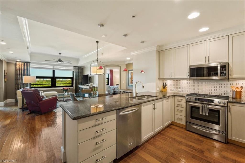 9115 Strada Place, Unit 5512 Naples, FL 34108 - Photo 42 of 42 a kitchen with stainless steel appliances granite countertop a stove a sink and a microwave