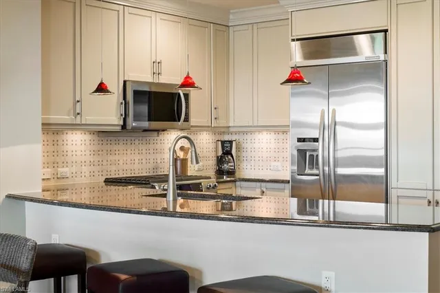 a kitchen with stainless steel appliances granite countertop a stove a sink and a microwave