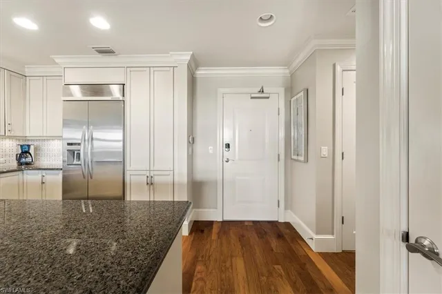 a kitchen with granite countertop a sink a stove and a refrigerator
