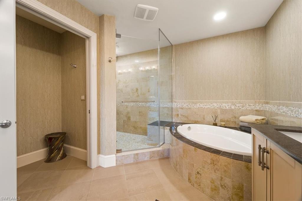 9115 Strada Place, Unit 5512 Naples, FL 34108 - Photo 18 of 42 a bathroom with a granite countertop sink a toilet a mirror and bathtub