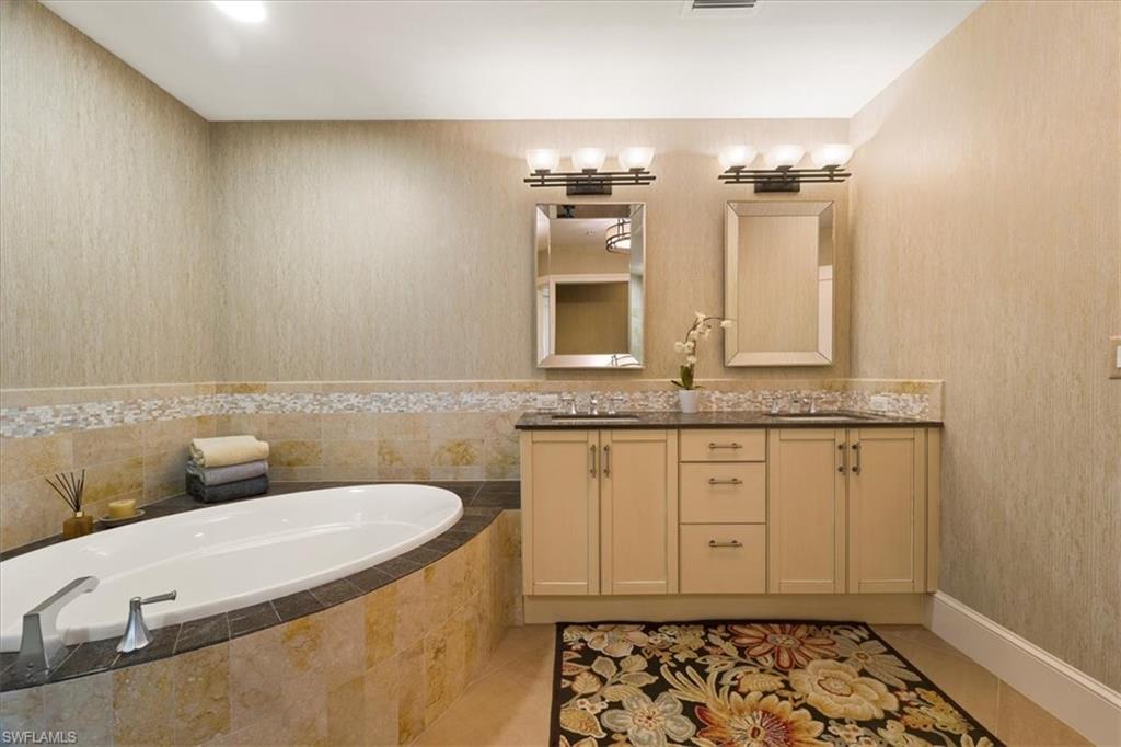 9115 Strada Place, Unit 5512 Naples, FL 34108 - Photo 19 of 42 a bathroom with a granite countertop sink and a mirror