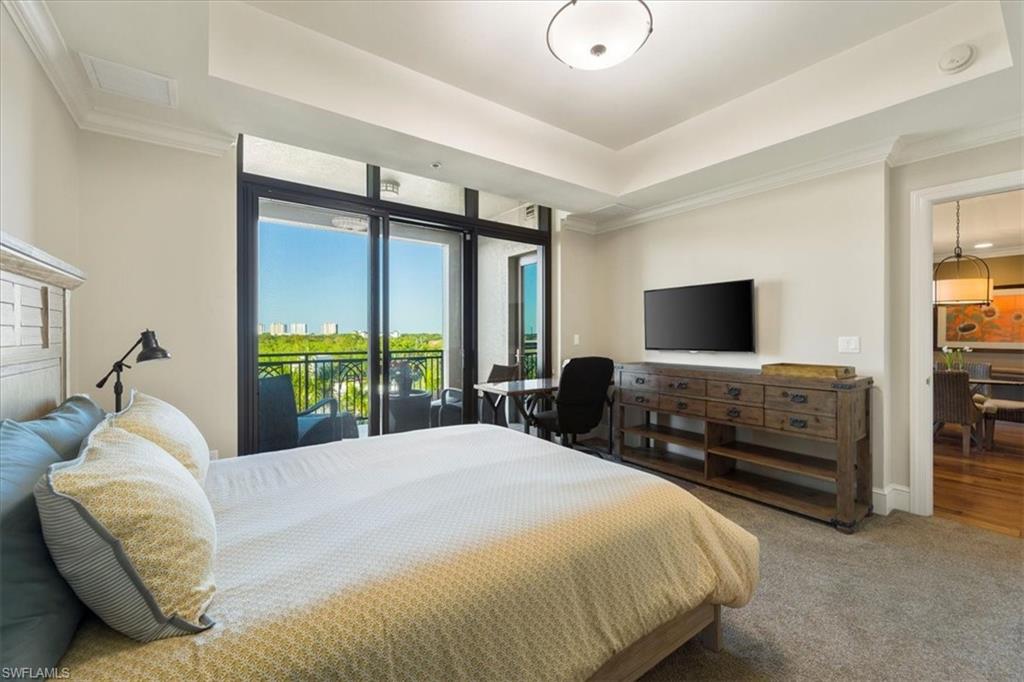 9115 Strada Place, Unit 5512 Naples, FL 34108 - Photo 20 of 42 a bedroom with a bed and a flat tv screen on dresser