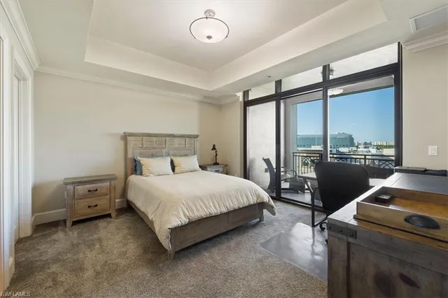 a bedroom with a bed and a flat tv screen on dresser