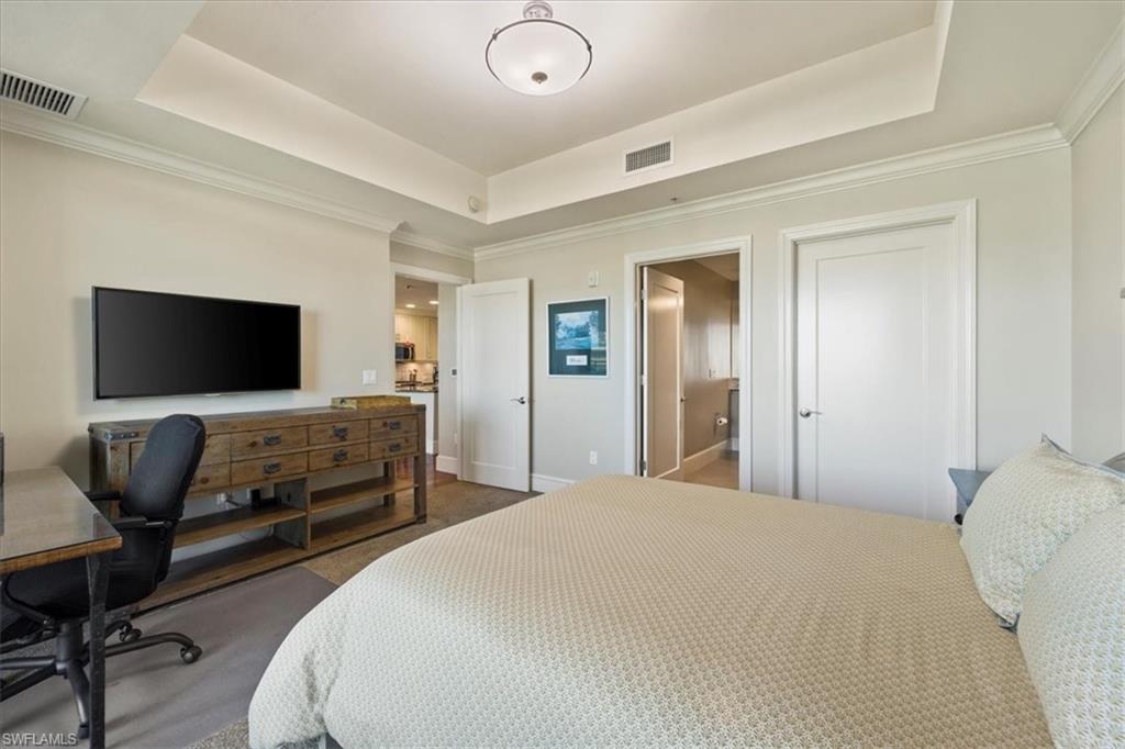 9115 Strada Place, Unit 5512 Naples, FL 34108 - Photo 23 of 42 a bedroom with a bed and a flat screen tv