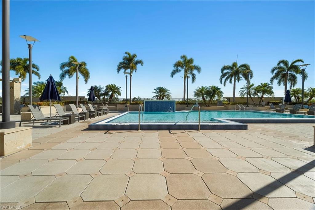 9115 Strada Place, Unit 5512 Naples, FL 34108 - Photo 30 of 42 a view of swimming pool with outdoor seating and palm trees