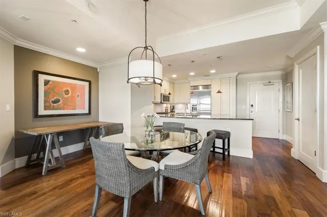 a view of a dining room and livingroom with furniture wooden floor a chandelier