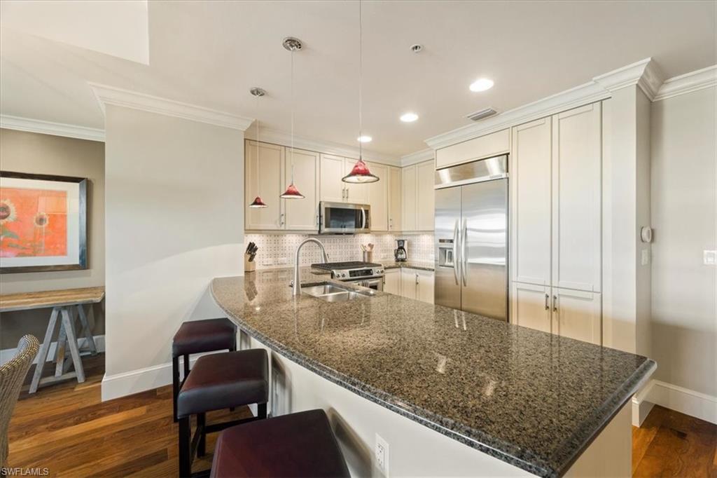 9115 Strada Place, Unit 5512 Naples, FL 34108 - Photo 10 of 42 a kitchen with stainless steel appliances granite countertop a sink refrigerator and cabinets