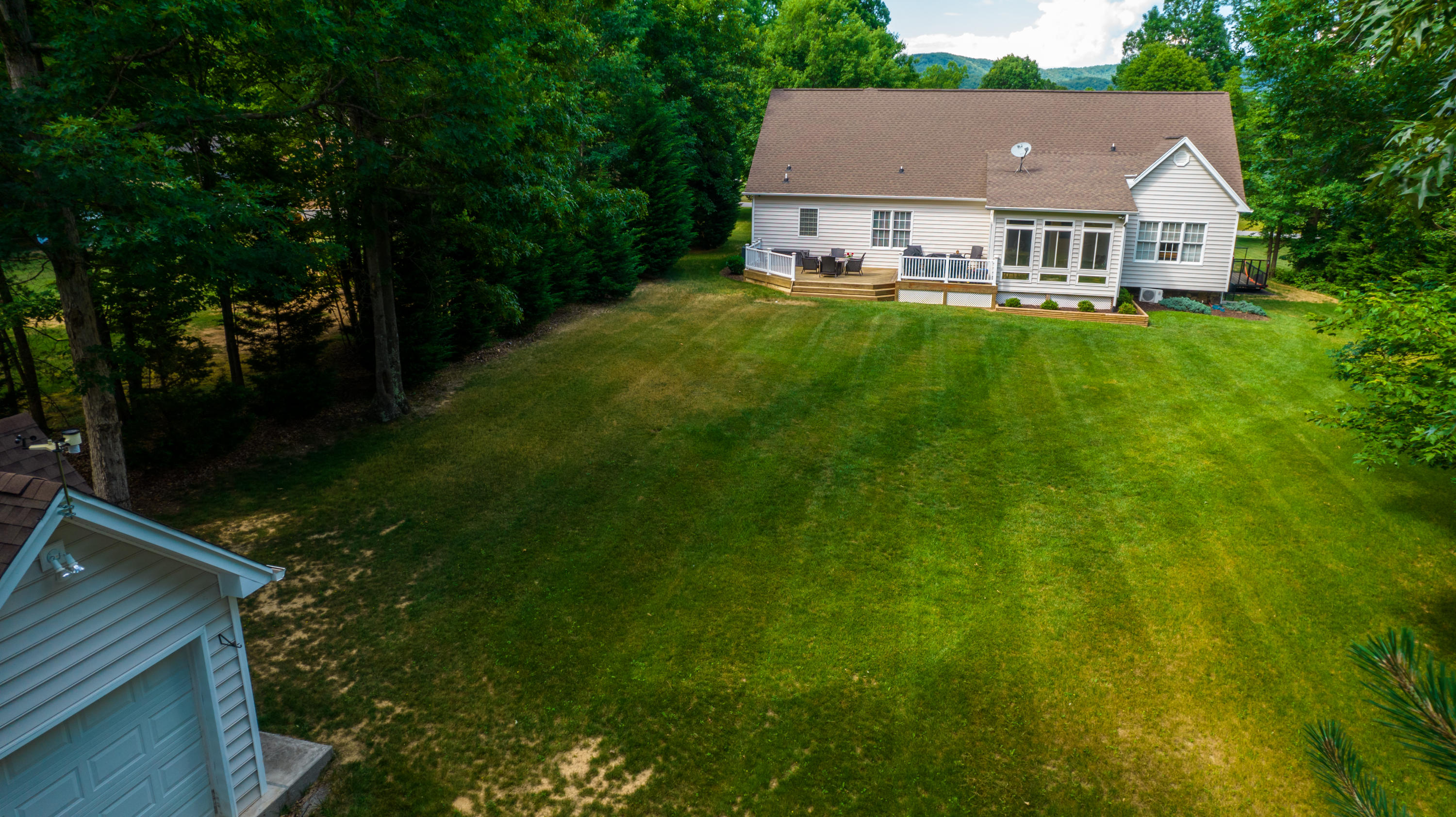74 Chesney Place Blue Ridge, VA 24064 - Photo 58 of 71 a view of a white house next to a big yard and large trees