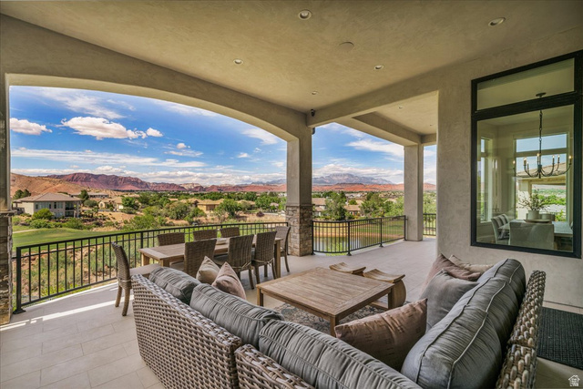 2608 Canyon Ridge Drive St. George, UT 84770 - Photo 47 of 86 Expansive covered patio featuring a tiled floor, stone-clad pillars, and a black wrought iron railing