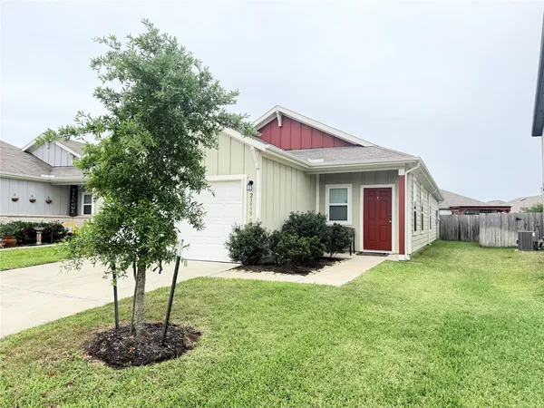 a front view of a house with a yard and potted plants