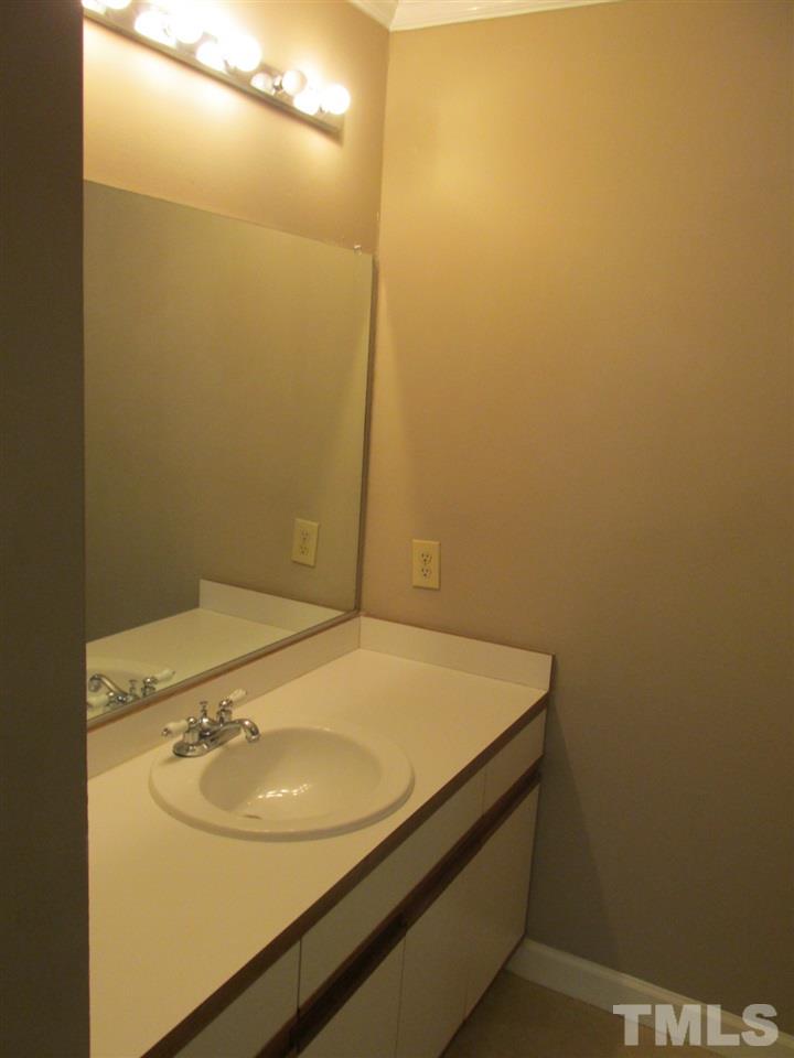 7040 Sandy Forks Road, Unit 207 Raleigh, NC 27615 - Photo 5 of 24 a bathroom with a sink and a mirror