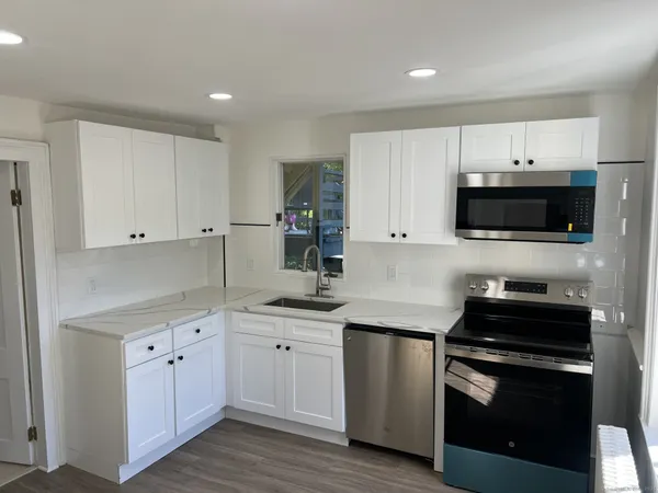 a kitchen with white cabinets stainless steel appliances and sink