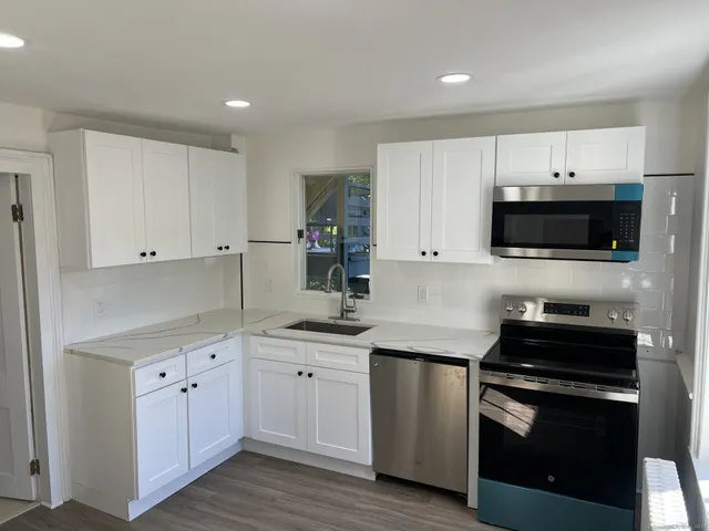 a kitchen with white cabinets stainless steel appliances and sink