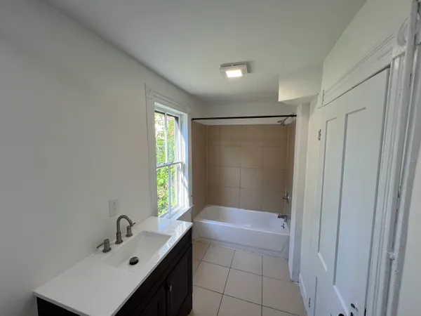 a bathroom with a bathtub sink vanity and a mirror