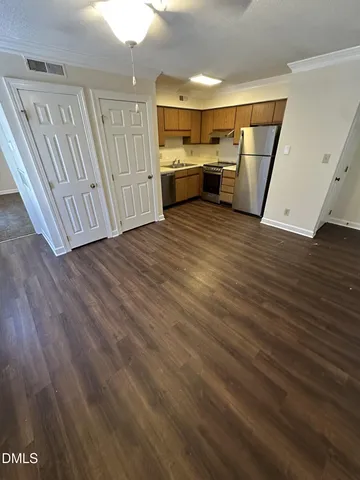 a view of a refrigerator in kitchen and wooden floor