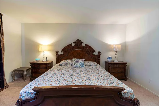 a bedroom with a bed wooden floor and lamp