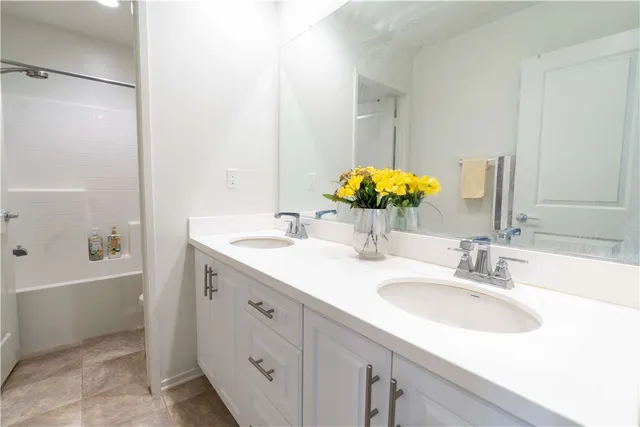 a bathroom with a sink tub vanity and a mirror