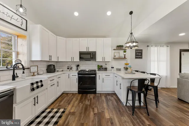 a kitchen with stainless steel appliances kitchen island granite countertop a sink stove and wooden floor