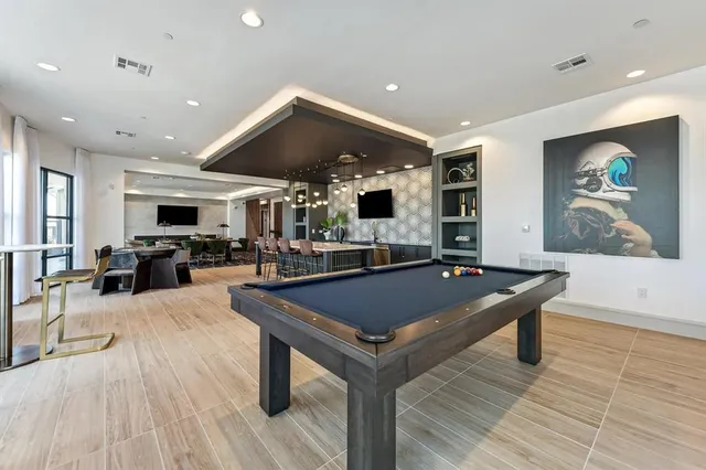 a living room with stainless steel appliances kitchen island granite countertop a couch and wooden floor